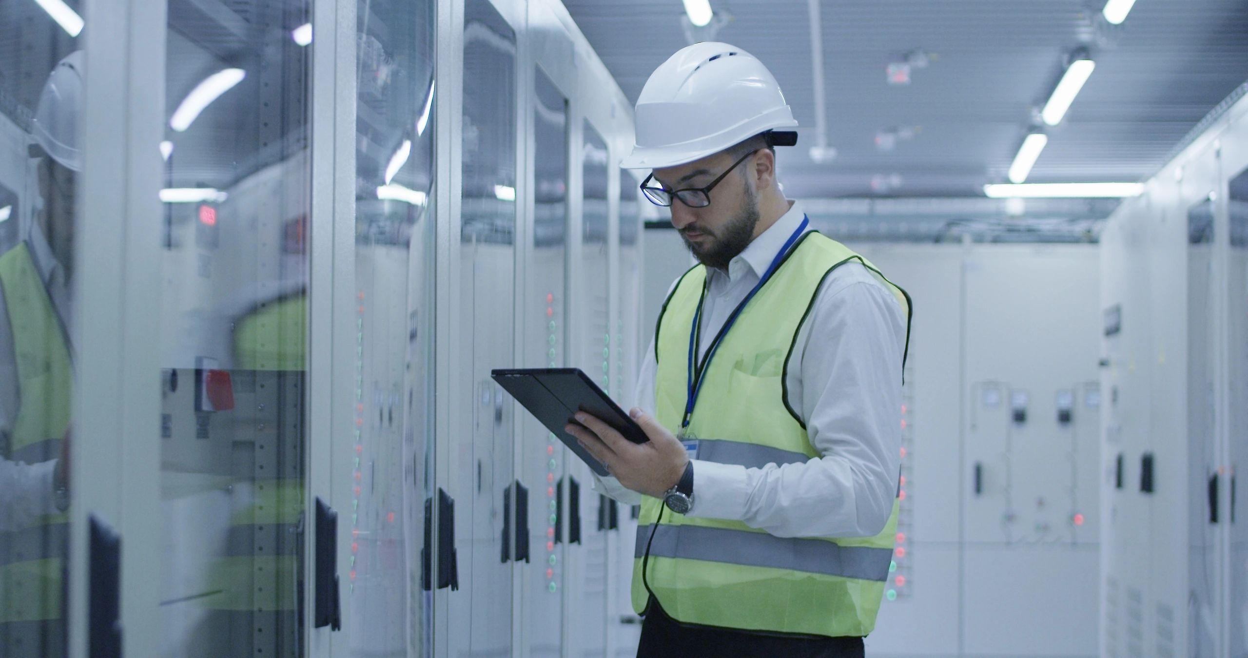 Electrical worker inspecting equipment using a tablet