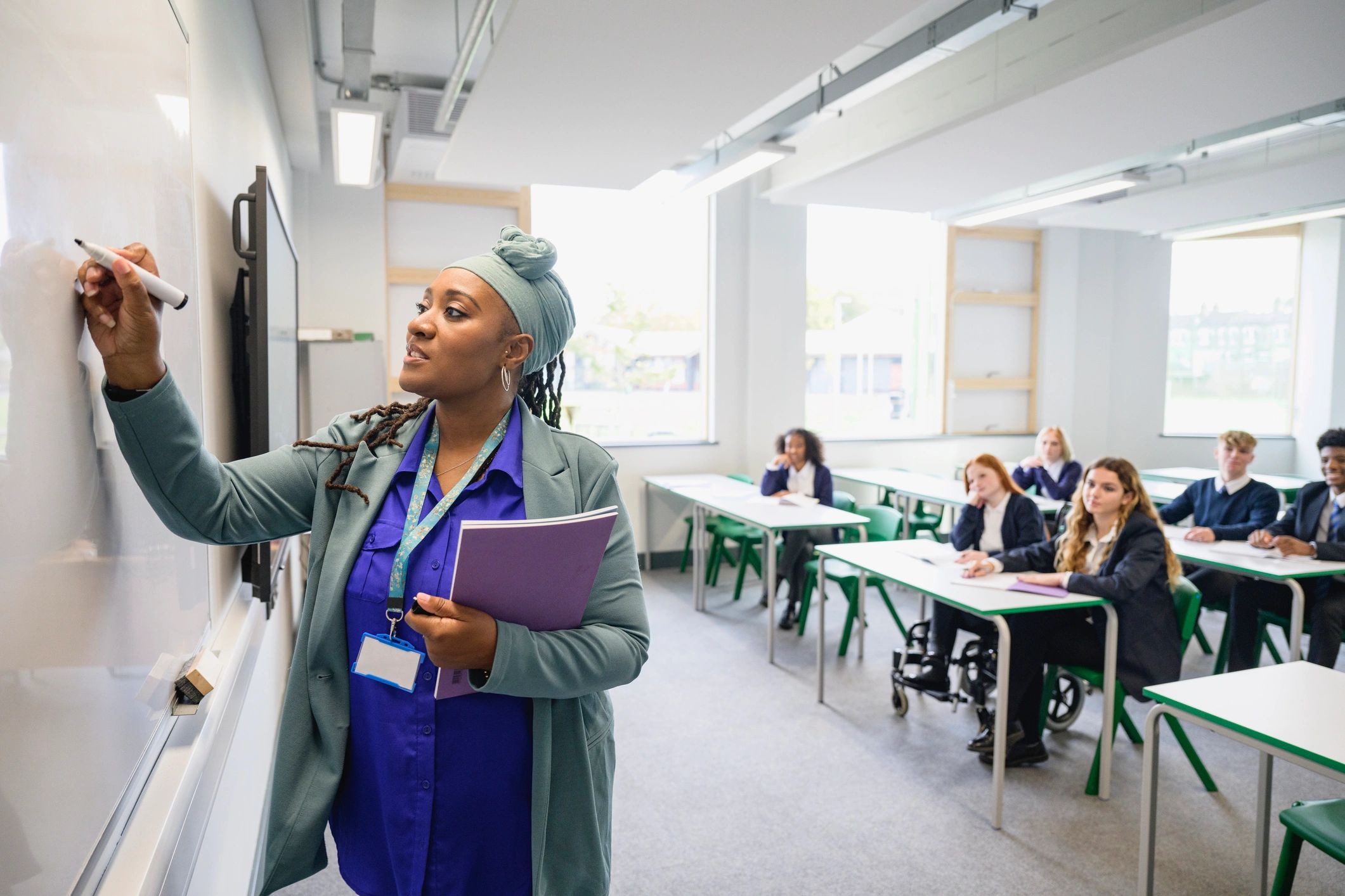Instructor writing on a whiteboard in a classroom