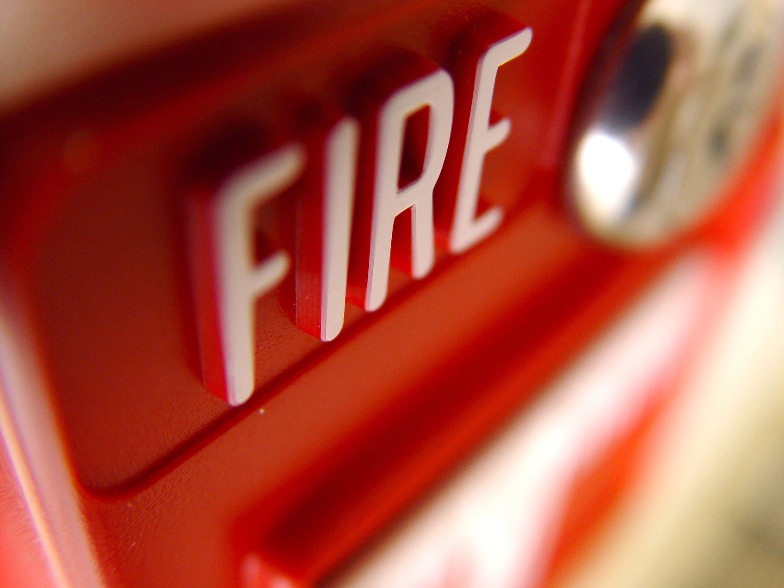 Close-up of a modern fire alarm call point on a wall in a commercial building