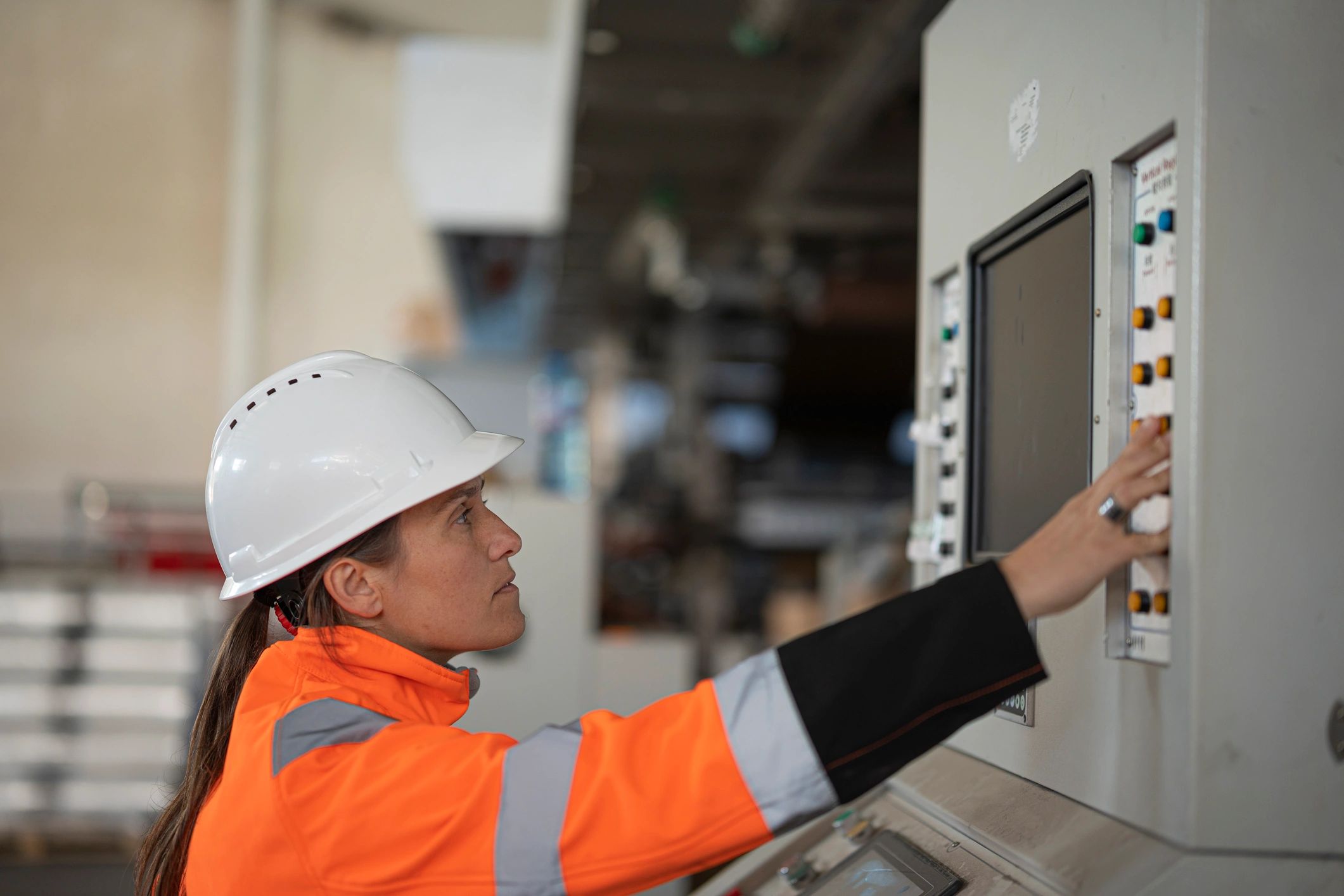 Engineer operating machinery controls in a factory